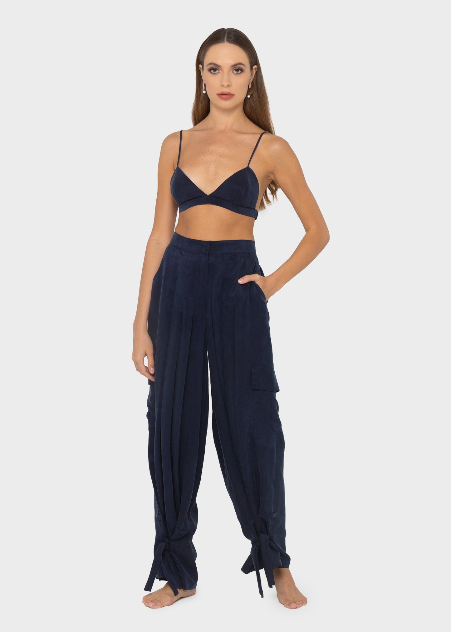 Woman wearing a navy triangle bralette with burgundy and navy color-block lounge pants