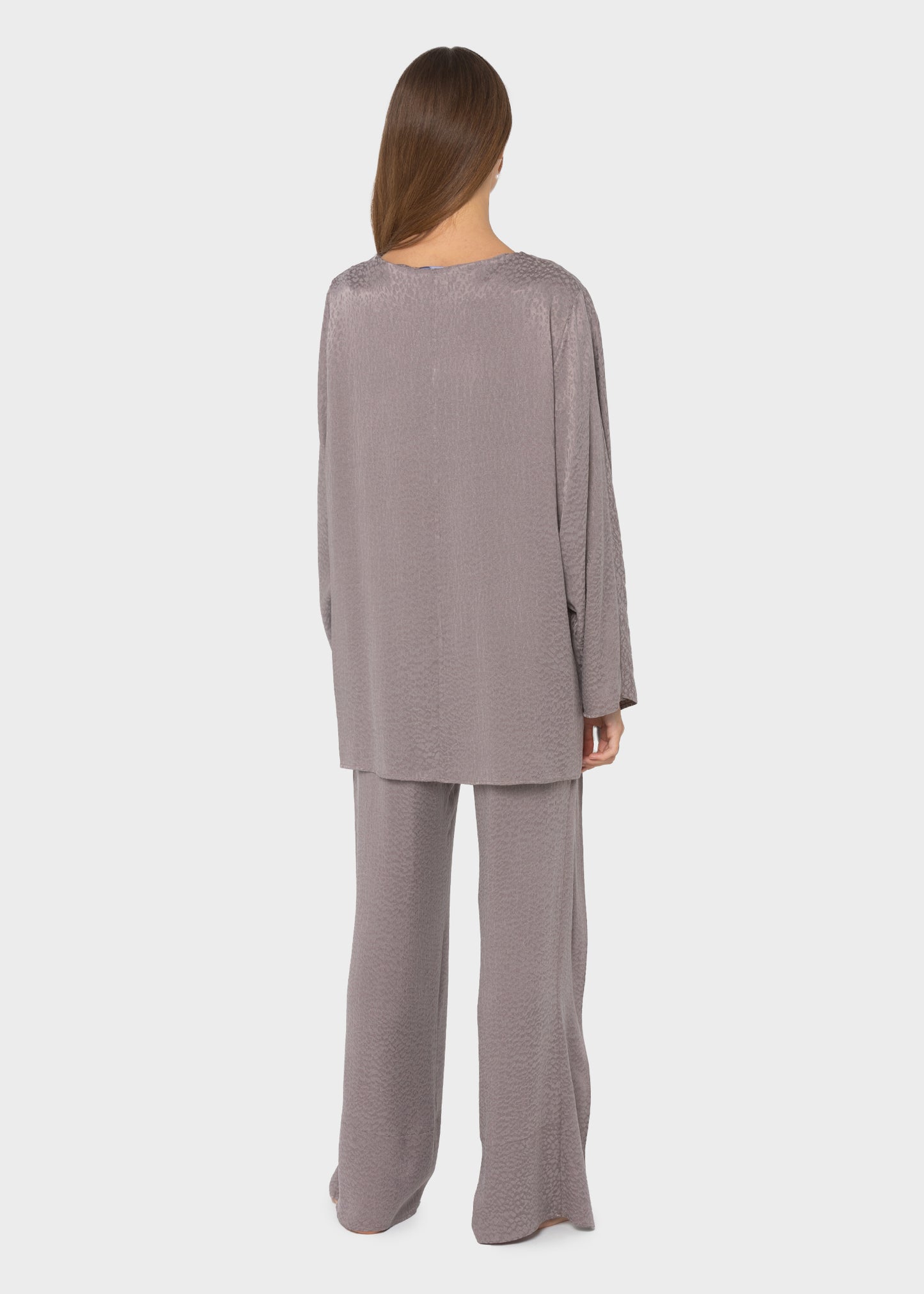 Woman wearing a gray long-sleeve lounge set with a relaxed oversized top and wide-leg pants