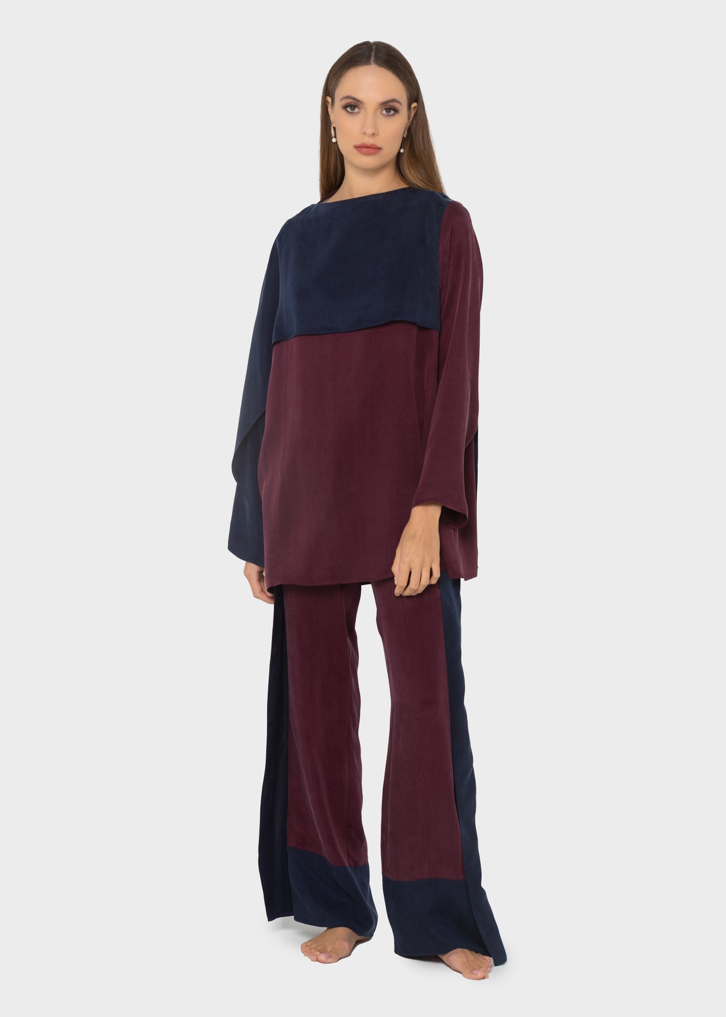 Woman wearing a navy and burgundy color-block oversized tunic with matching burgundy and navy pants