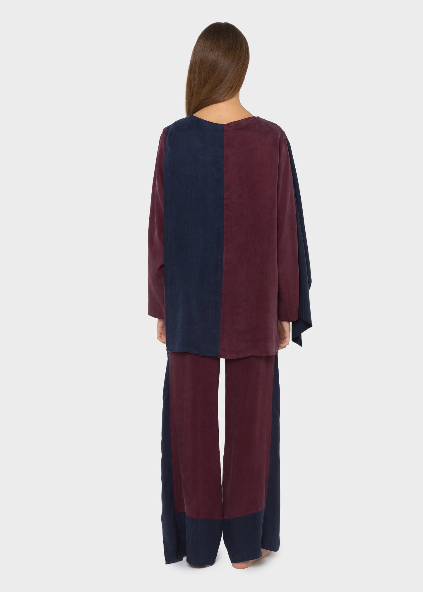 Woman wearing a burgundy wrap blazer with matching burgundy and navy wide-leg pants