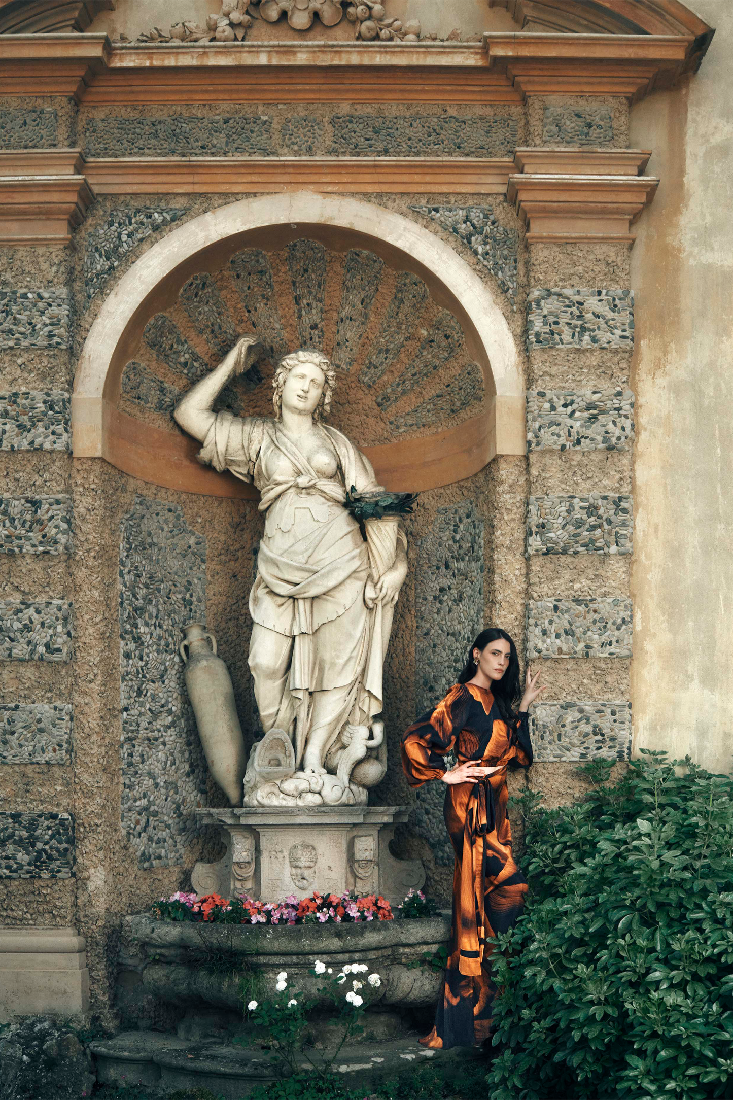 Women wearing a luxury, sustainable vegan silk printed wrap top with long sleeves and a matching tie-waist maxi skirt in orange and navy.