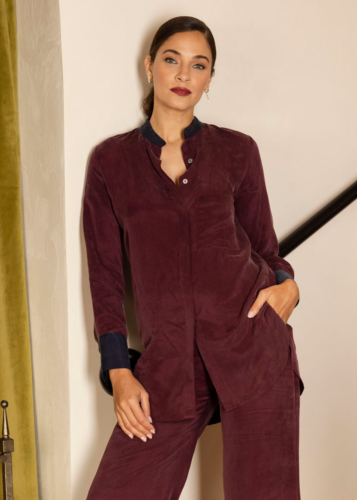 Women wearing a burgundy vegan silk button-up top with matching wide-leg pants.