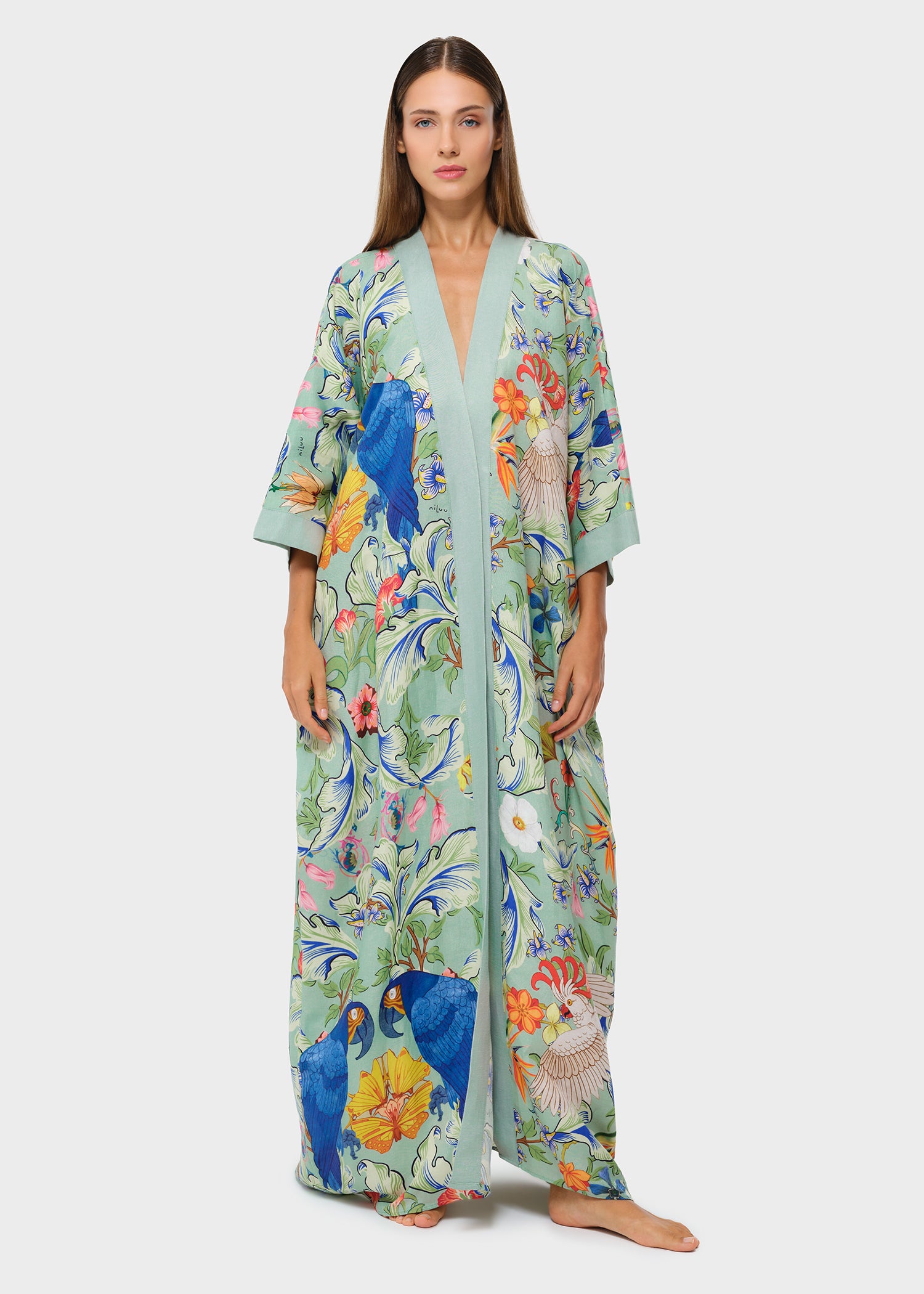 Model wearing a mint green printed maxi robe with bird and floral motif.