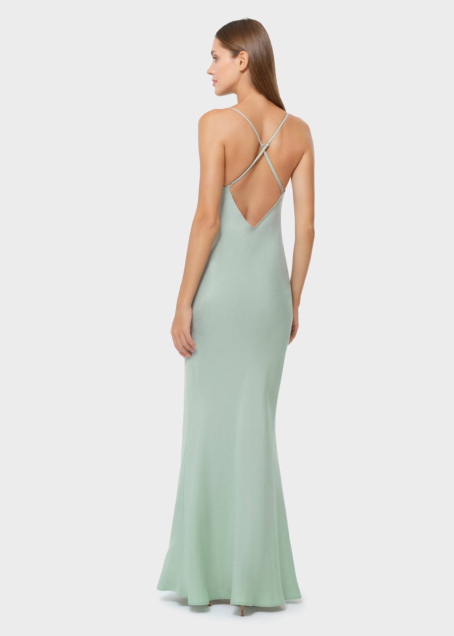 Woman wearing mint green vegan silk slip maxi dress with open back, rear view