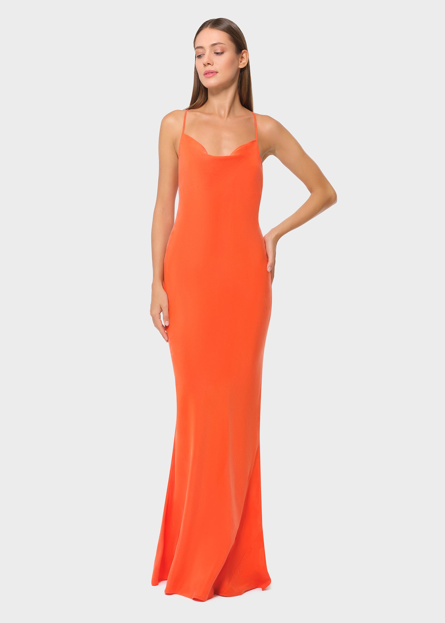 Woman wearing bright orange vegan silk slip maxi dress, angled front view