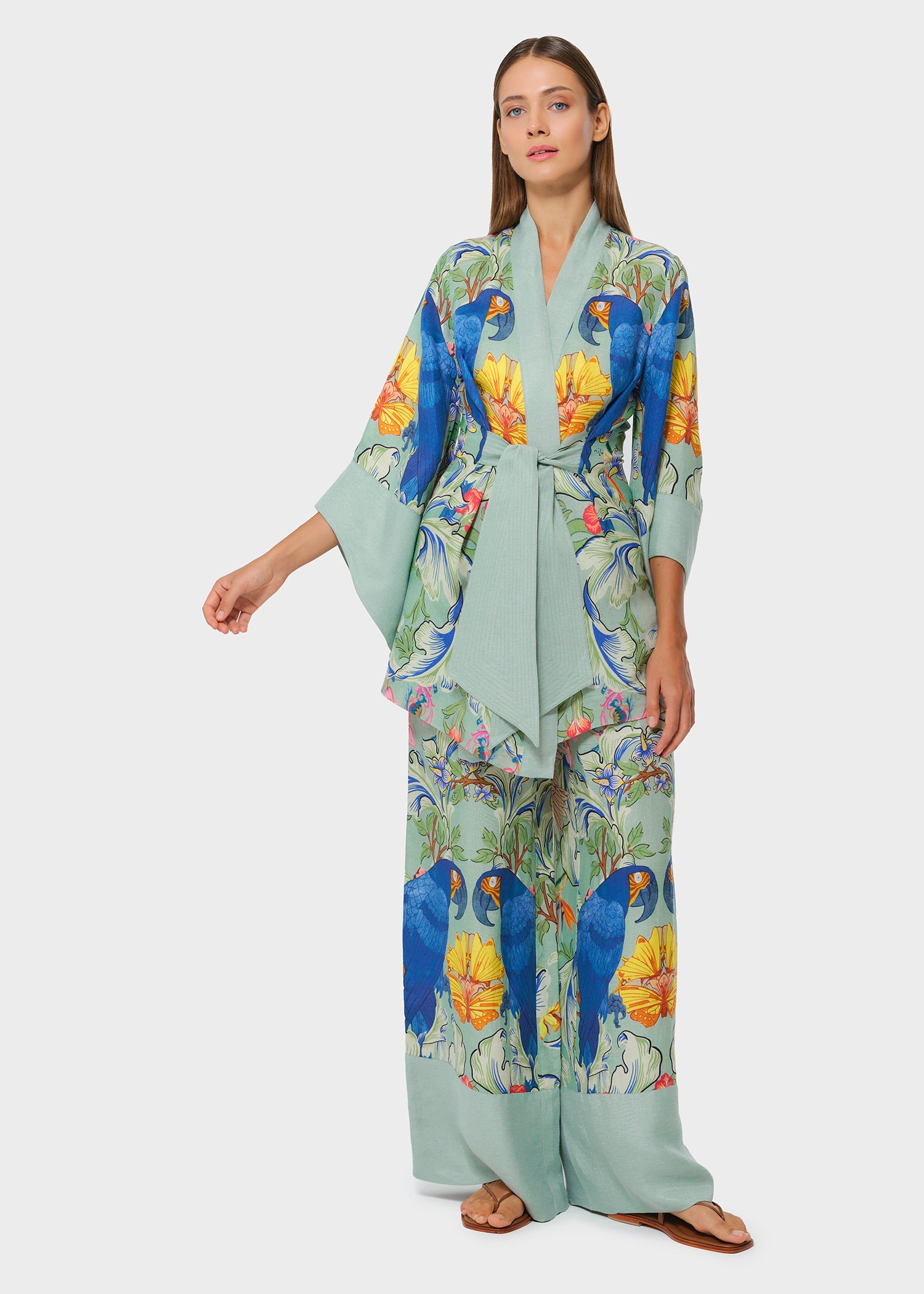 Model wearing printed sage green robe with matching wide-leg pants on studio background
