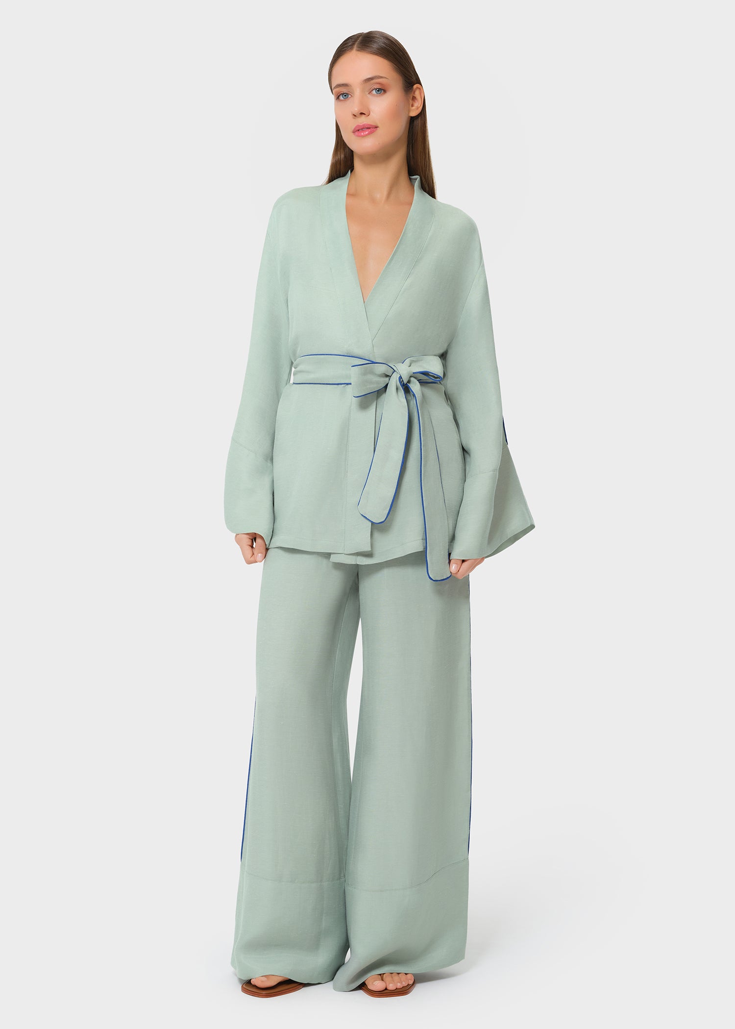 Model wearing a sage green halter wrap top with matching wide-leg pants, front view on studio background