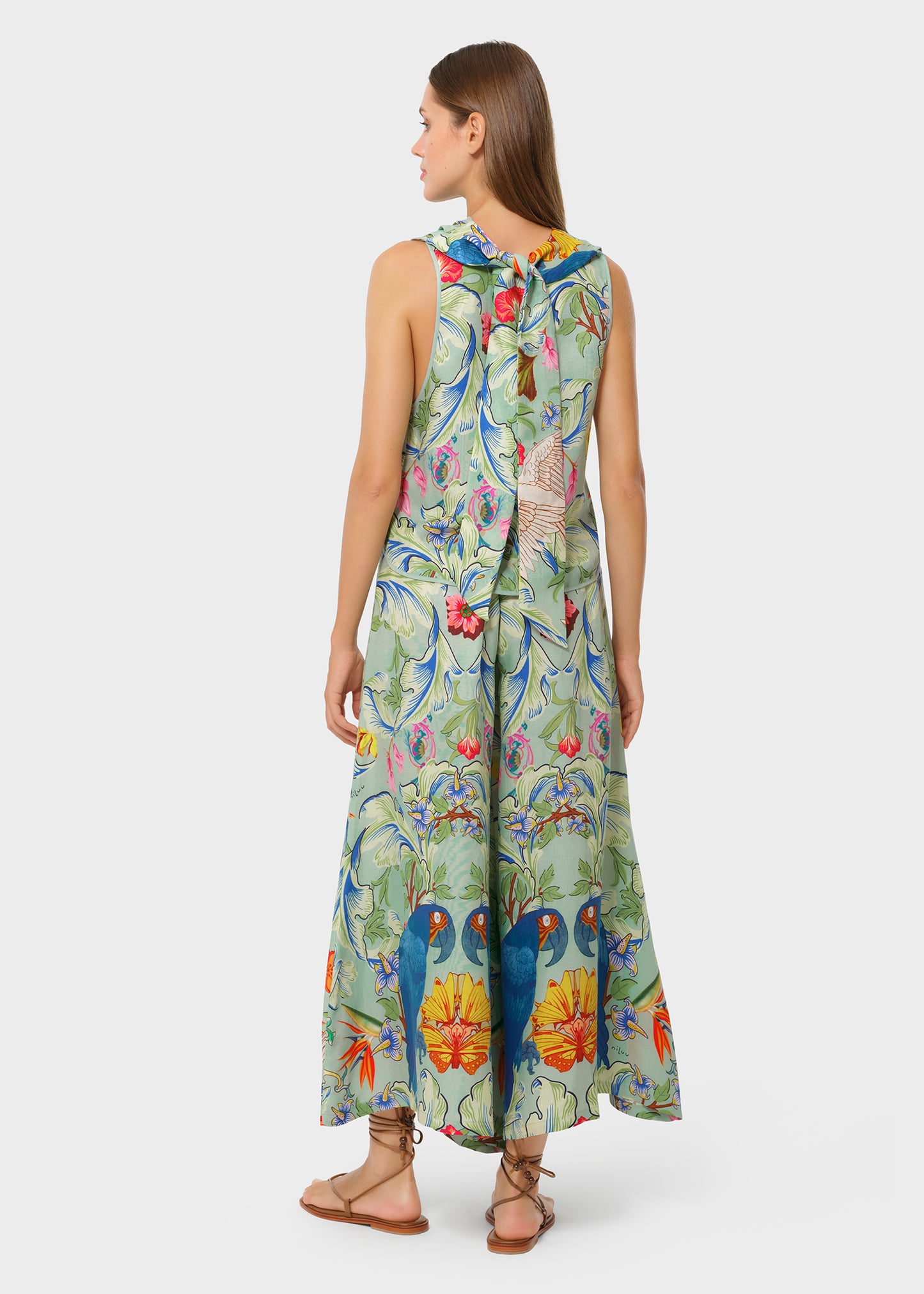 Back view of the tropical printed co-ord set with florals and blue parrots. Sleeveless top with a soft tie detail, paired with wide-leg flowy pants.
