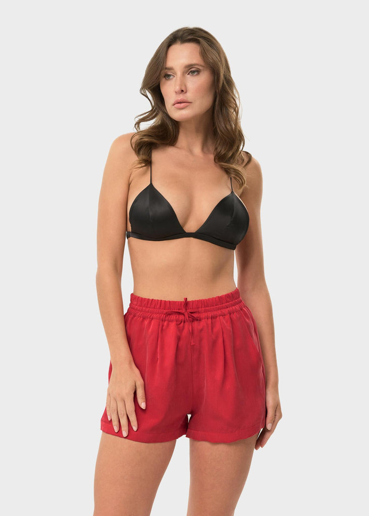 Woman wearing red drawstring shorts.