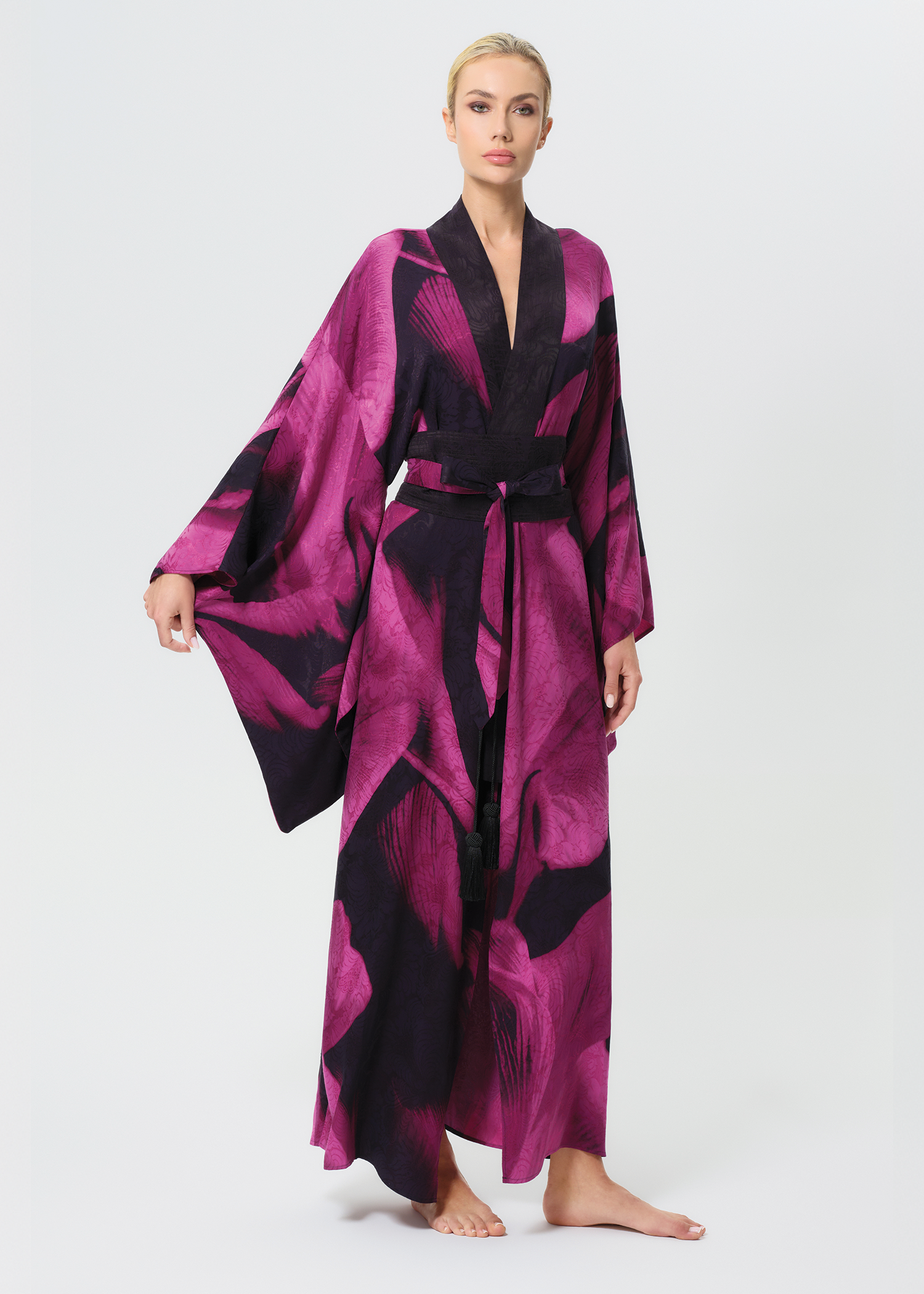 Woman wearing a pink and black patterned robe on a white background