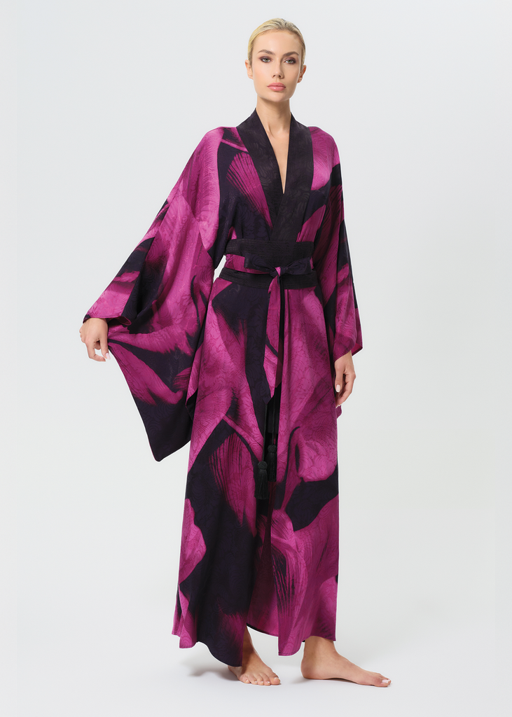 Woman wearing a pink and black patterned robe on a white background