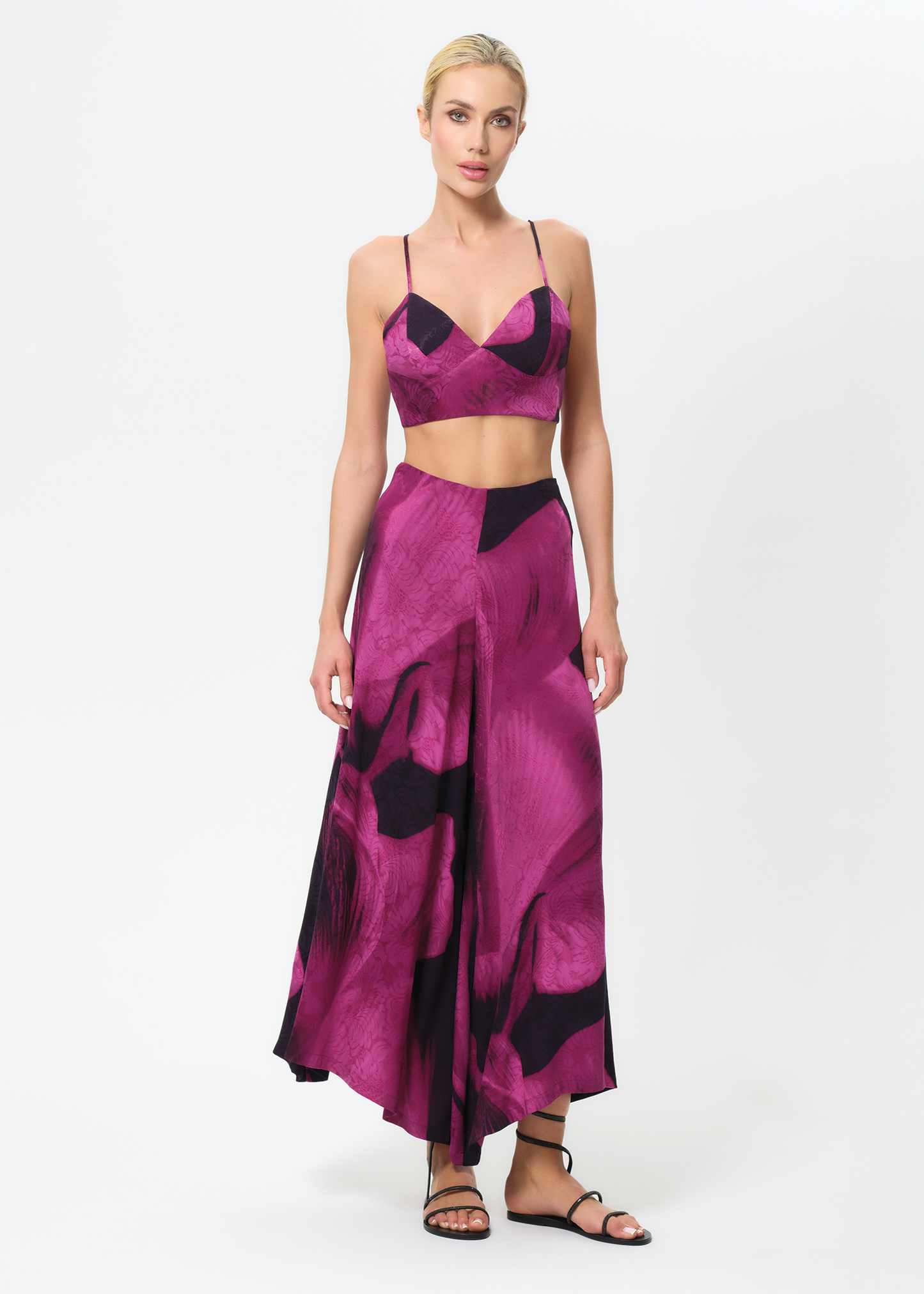 Woman wearing a pink and black patterned outfit on a white background