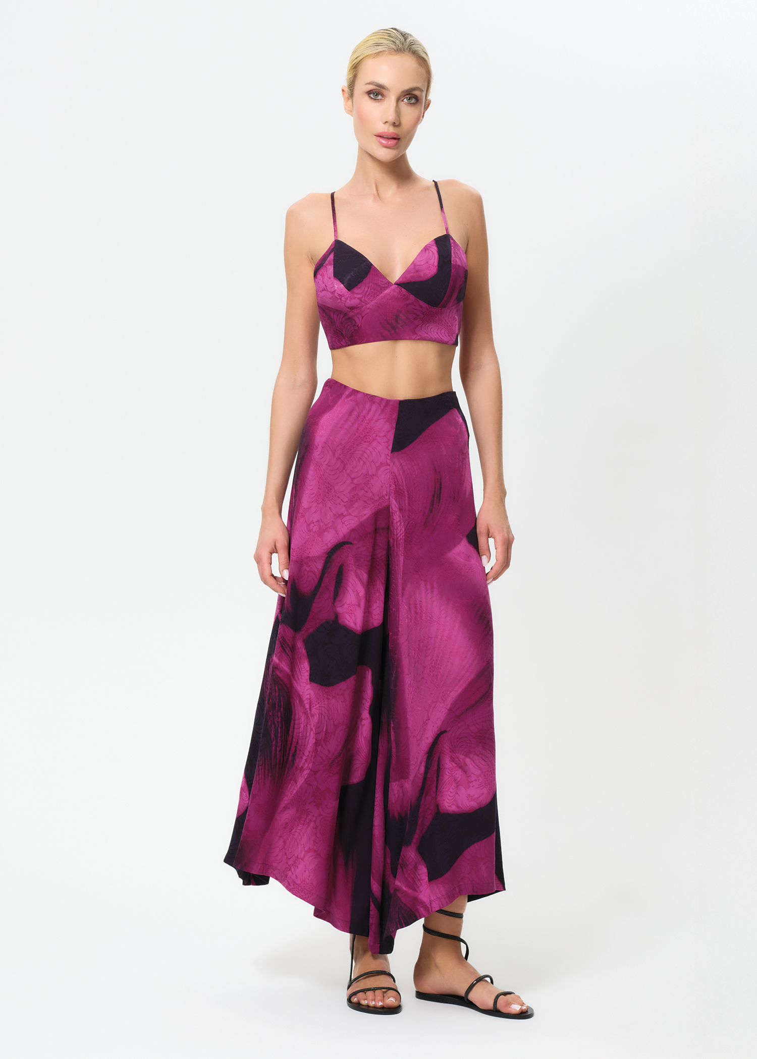 Woman wearing a pink and black patterned outfit on a white background