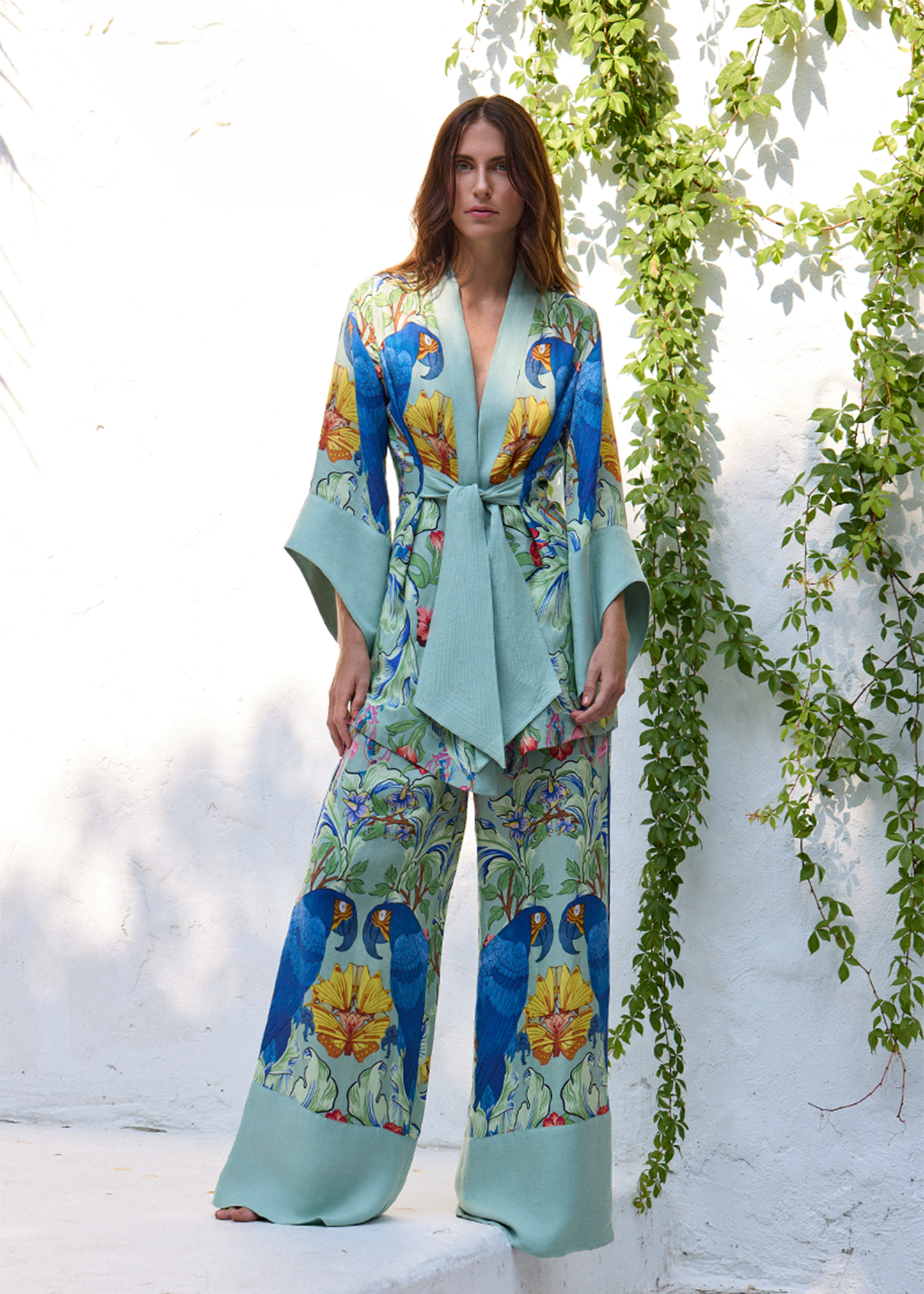 Green parrot print wrap top and wide-leg pants set with tie waist, shown outdoors.