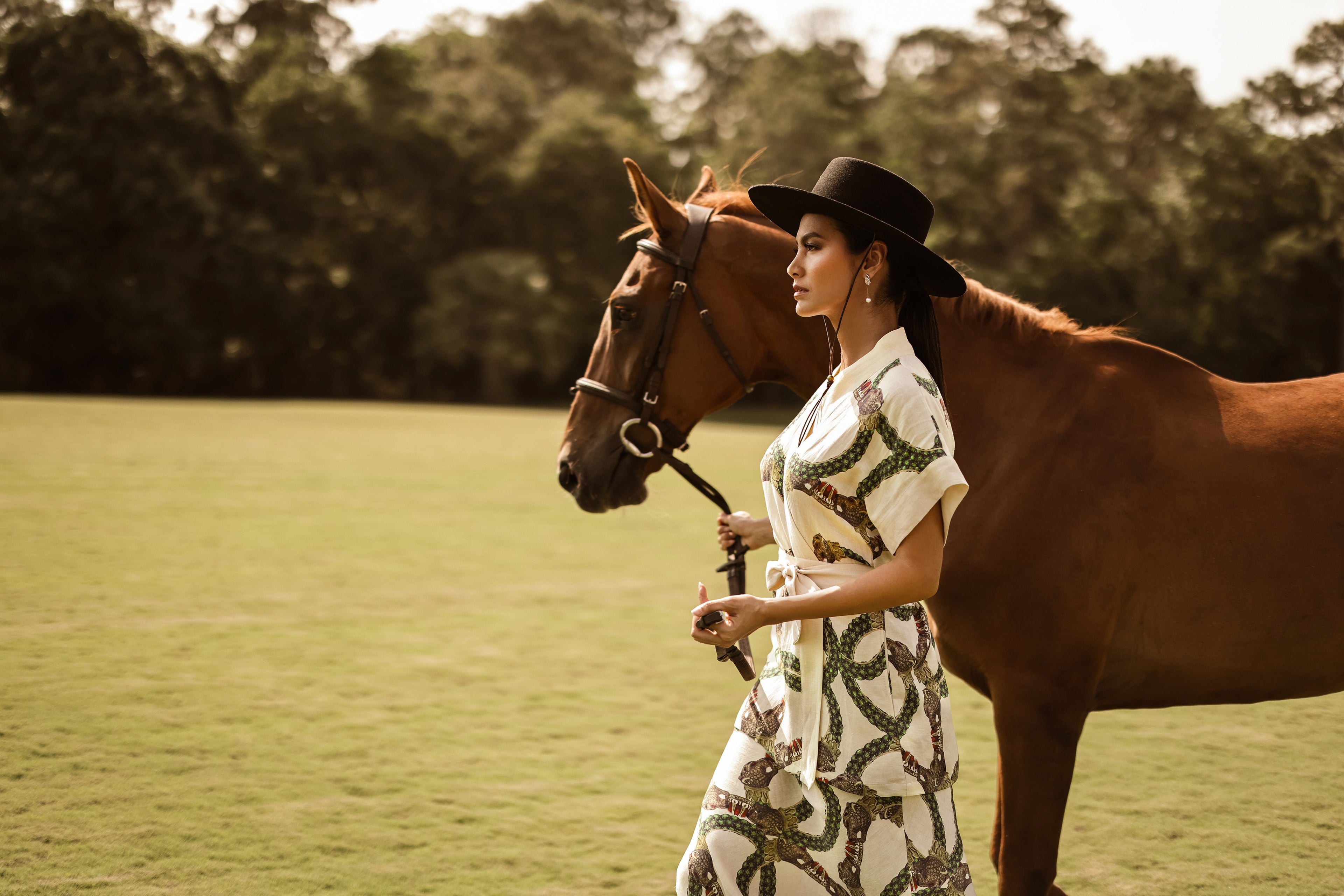 The model is wearing Celine's short-sleeve wrap top and slip skirt while walking with a horse.